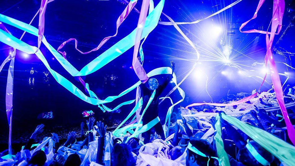 Blue Man Group member and concert crowd playing in streamers at their concert in NYC, New York