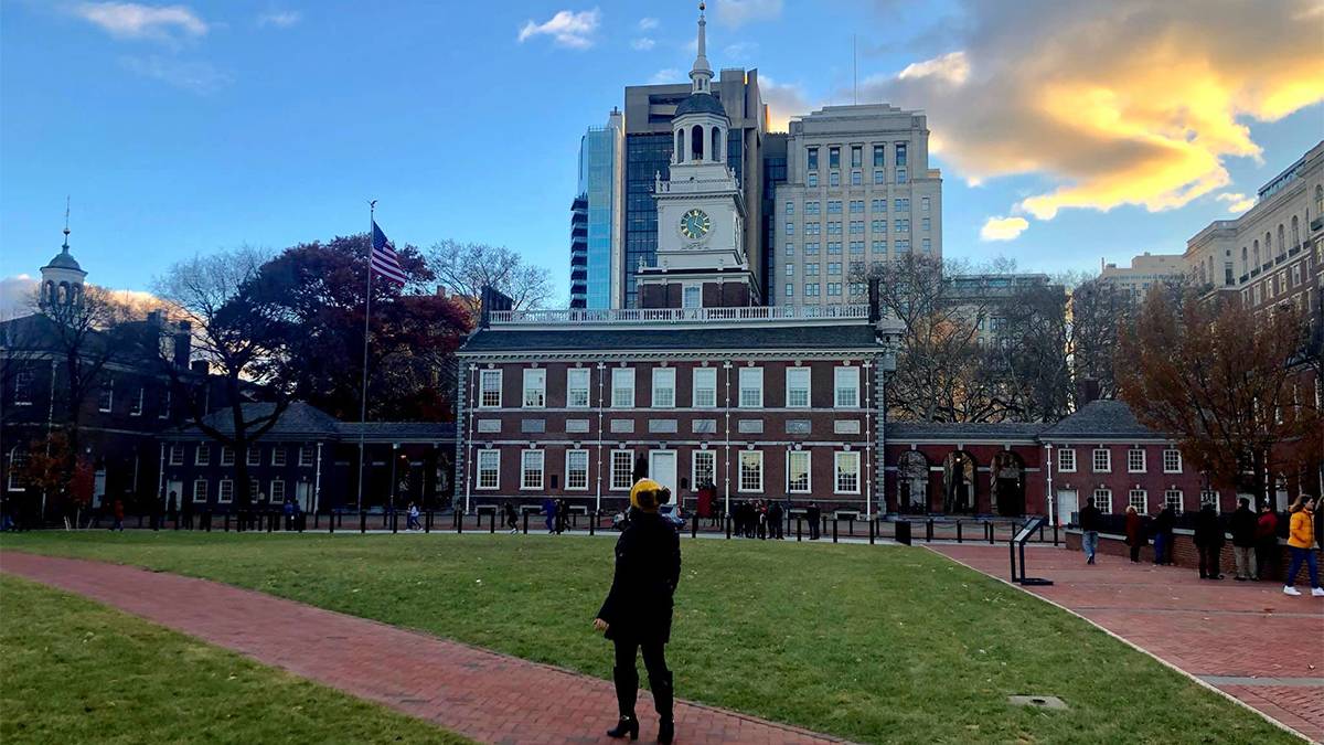 Girl with her back turned to the camera looking up at Independence Hall in Philadelphia, Pennsylvania