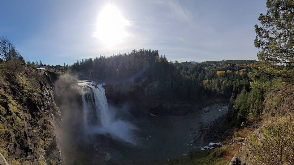 Wide shot of Snoqualmie Falls with the sun over it in Seattle, Washington, USA
