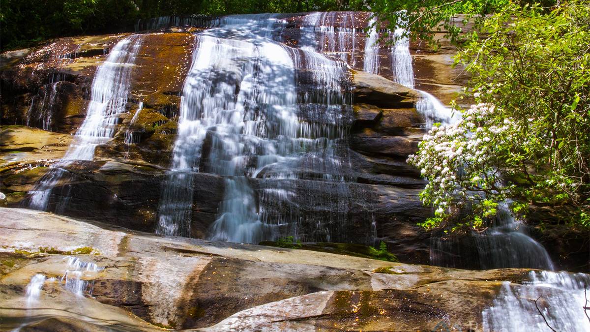 Close up photo of Cove Creek Falls in Pisgah National Forrest on a sunny day in Asheville, North Carolina, USA