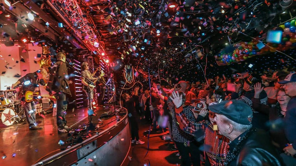 Side view of the stage and audience cursing the ball drop with tons of confetti at Pierce Arrow Theater's New Year's Eve Party in Branson, Missouri, USA