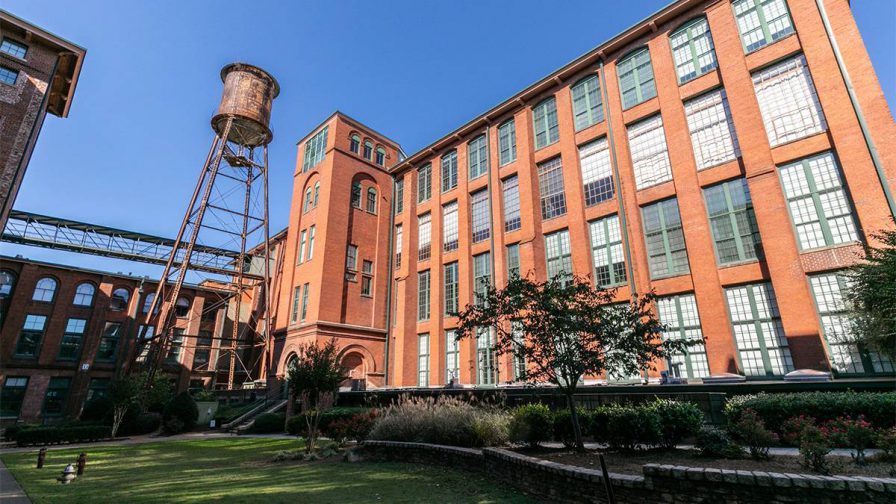 Looking up at the Fulton Cotton Mill Lofts from the park area for the residents on a sunny day in Atlanta, Georgia, USA