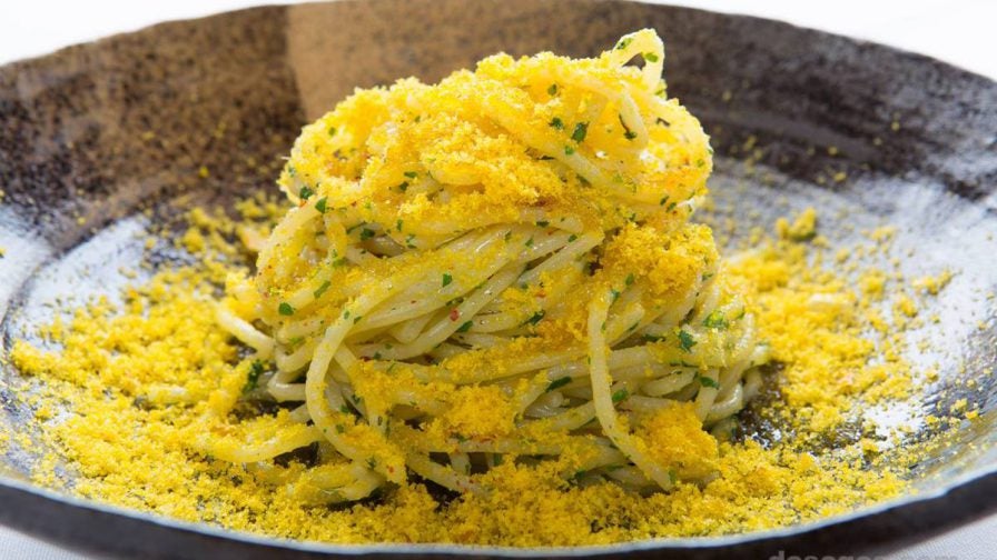 A bright yellow pasta dish on a black plate with a white back ground from La Ciccia in San Francisco, California, USA