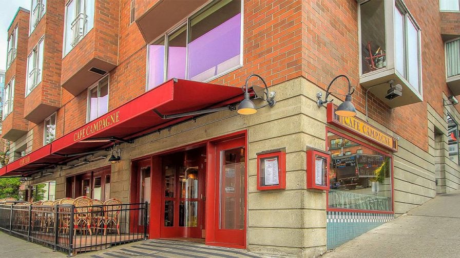 Exterior view of Cafe Campagne with its red doors and awning in Seattle, Washington, USA