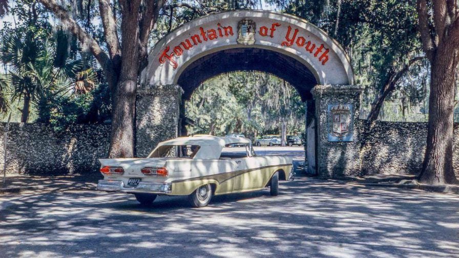A vintage car driving through the archway to the Fountain of Youth in St Augustine, Florida, USA