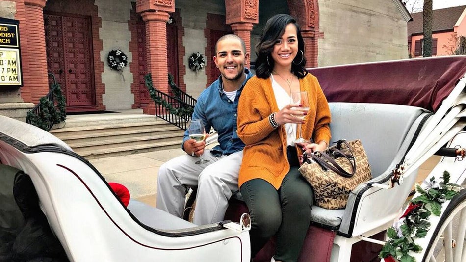 Couple holding wine glasses sitting in a white carriage ready to go on Private Carriage Ride in St Augustine, Florida, USA