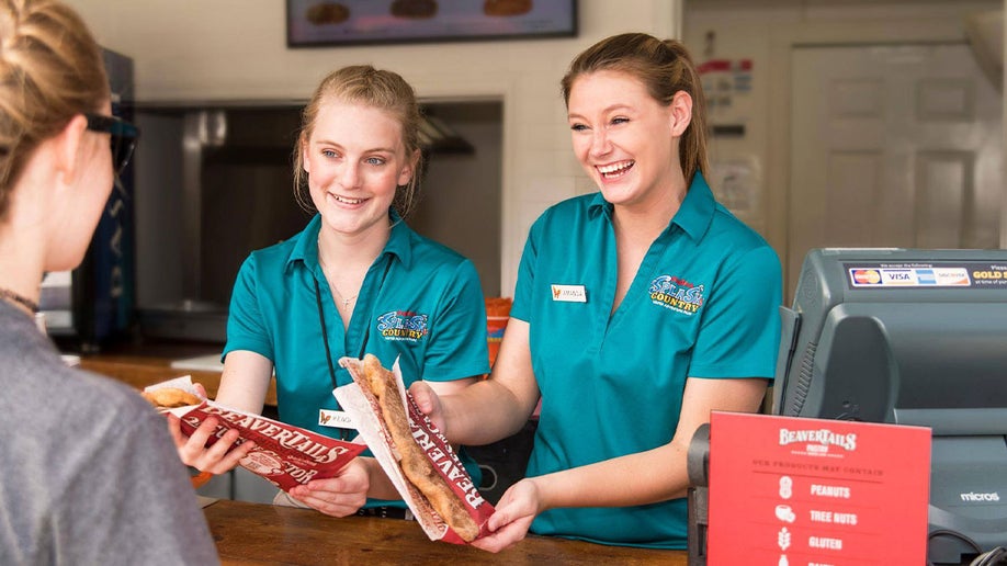 staff serving customer two BeaverTails Pastries at Dollywood Splash Country in Pigeon Forge, Tennessee, USA