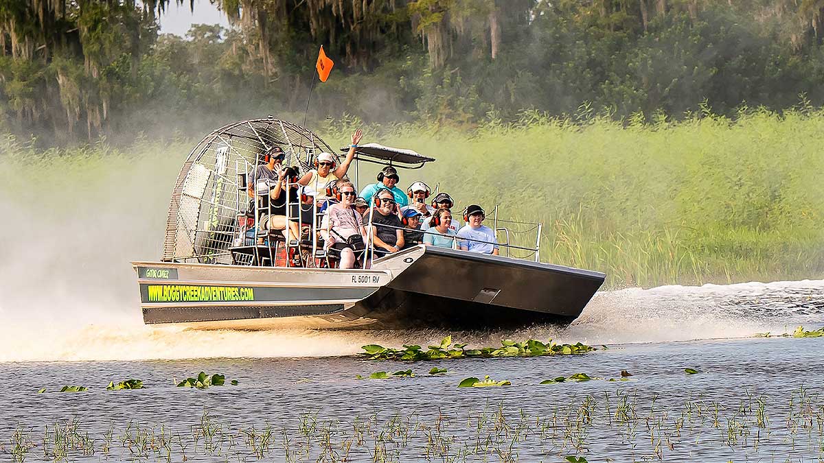 A group of people are enjoying the ride of an airboat adventure.
