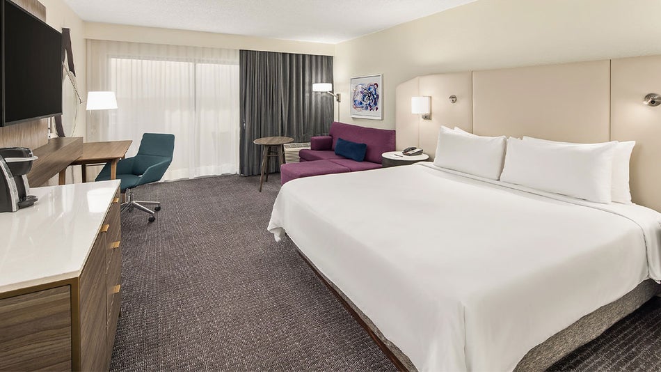 guest room with capeted floor, large bed, flatscreen tv, sofa at Crowne Plaza Orlando Lake Buena Vista in Orlando, Florida, USA
