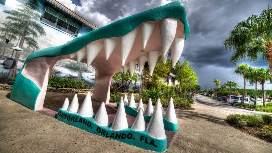 angled shot of entrance to Gatorland with close up of statue of open gator mouth in Orlando, Florida, USA