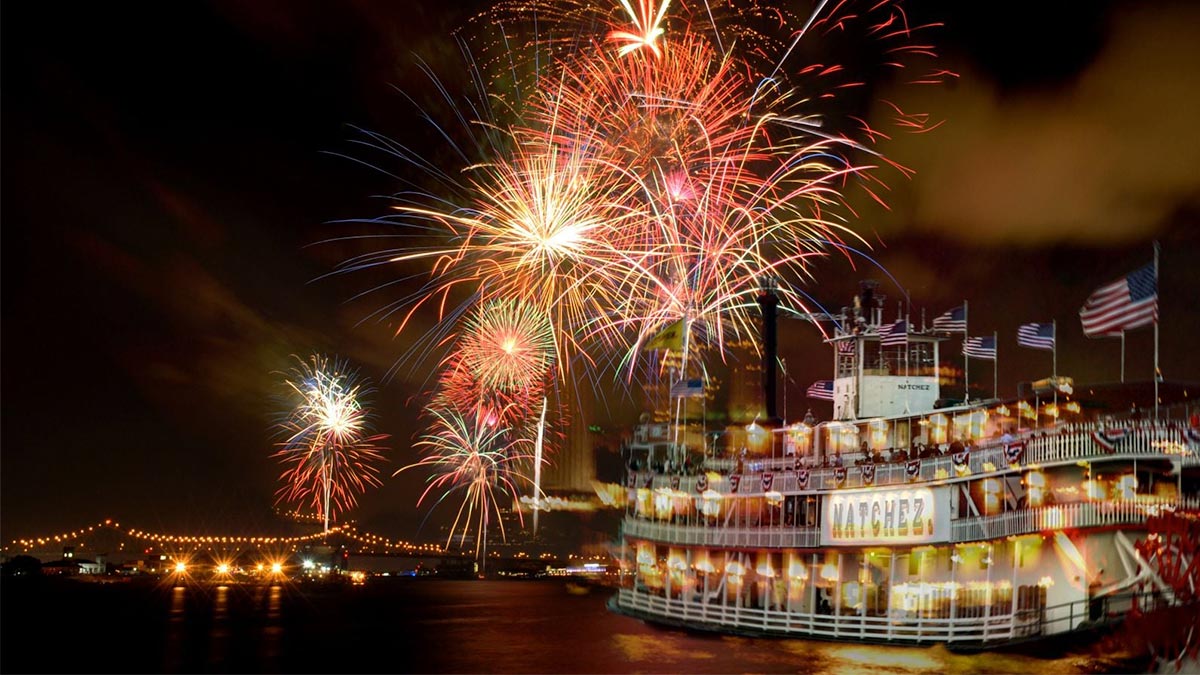 boat with american flags on water with fireworks in sky at Fourth on the River in New Orleans, Louisiana, USA
