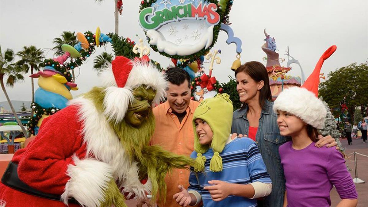 family interacting with Grinch mascot for Grinchmas at Universal Studios Orlando in Orlando, Florida, USA