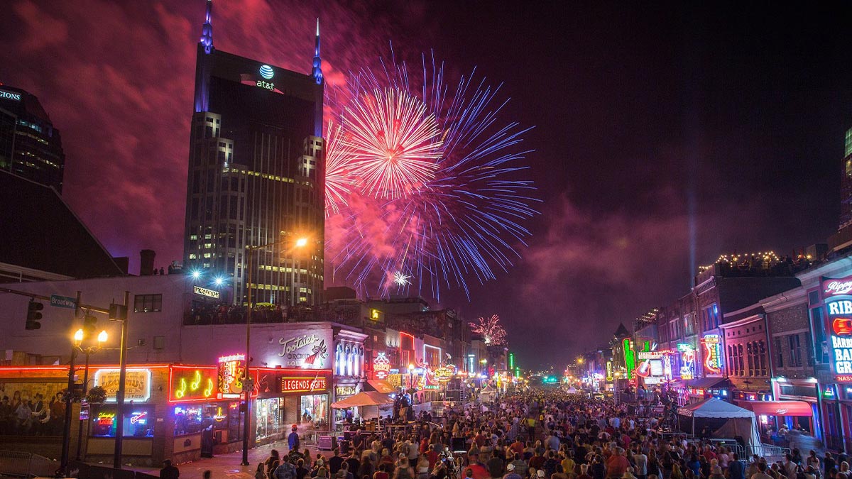 crowd of people on street at night with fireworks in sky at Let Freedom Sing! Music City event in Nashville, Tennessee, USA