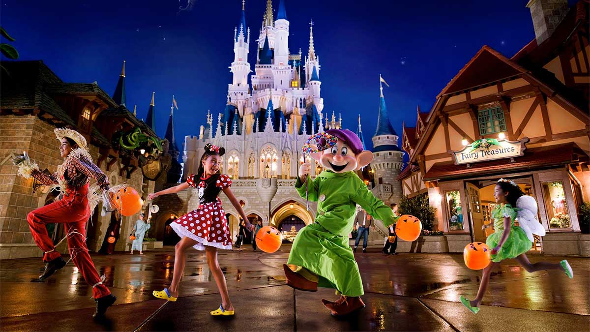 children in costume with mascot walking through disney world with stores and castle in background at Disney World, Orlando, Florida, USA