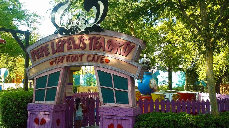 child at entrance of Pepe Le Pew's Tea Party surrounded by greenery at Six Flags Magic Mountain in Los Angeles, California, USA
