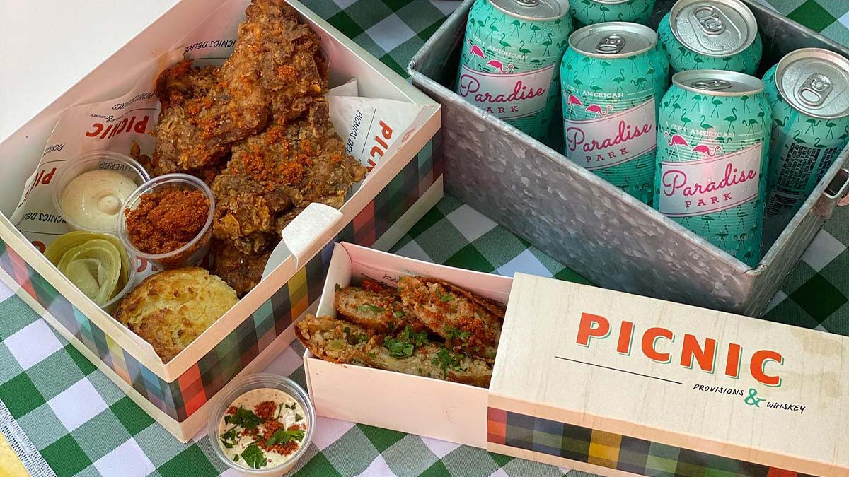 close up of food and drinks in boxes over green gingham cloth from Picnic Provisions Food in New Orleans, Louisiana, USA