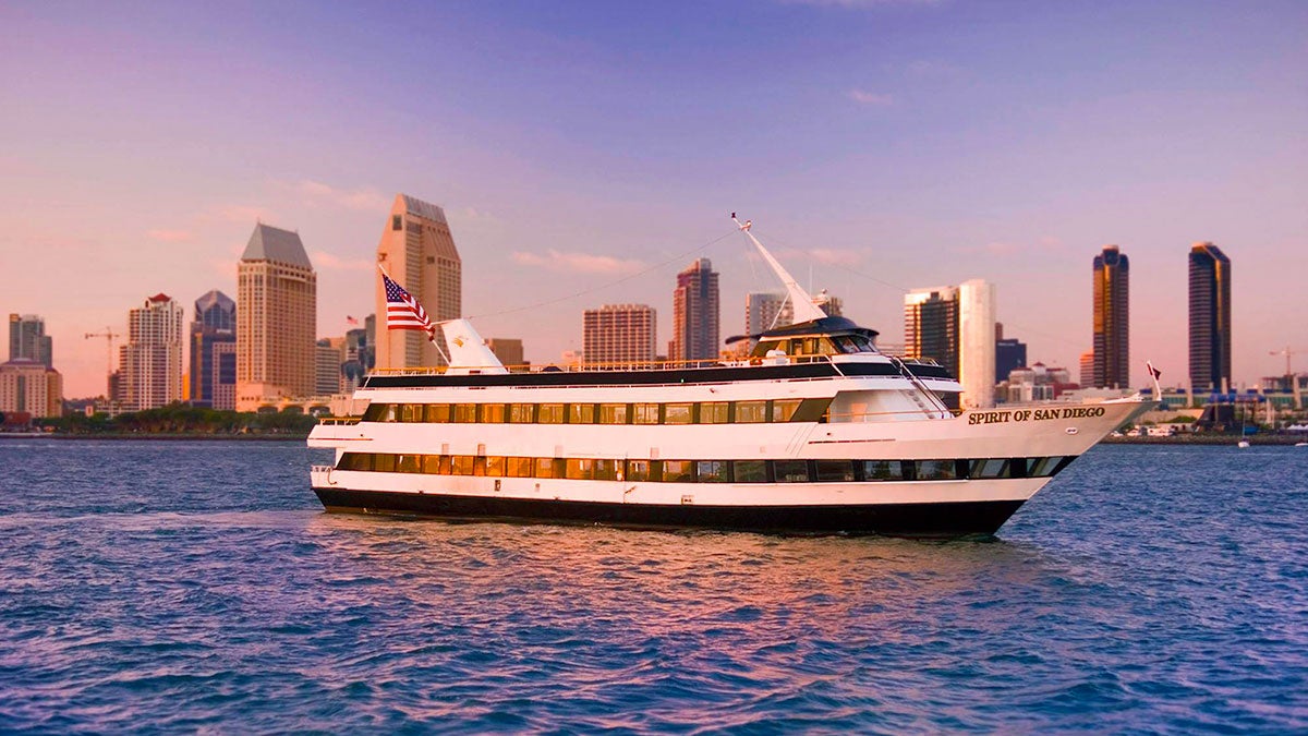 Flagship cruise on water with San Diego skyline in background during sunset at San Diego, California, USA