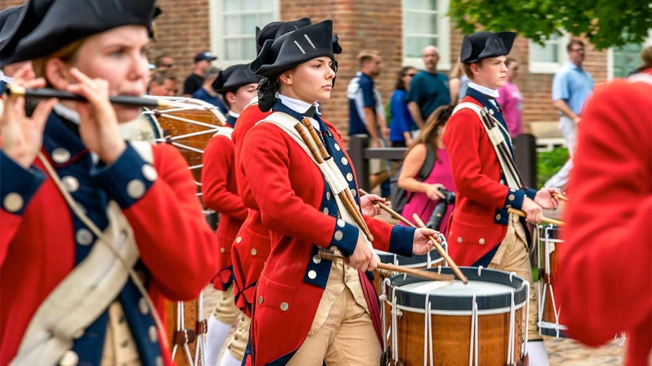 a picture of a man and a woman holding a drum in the parade