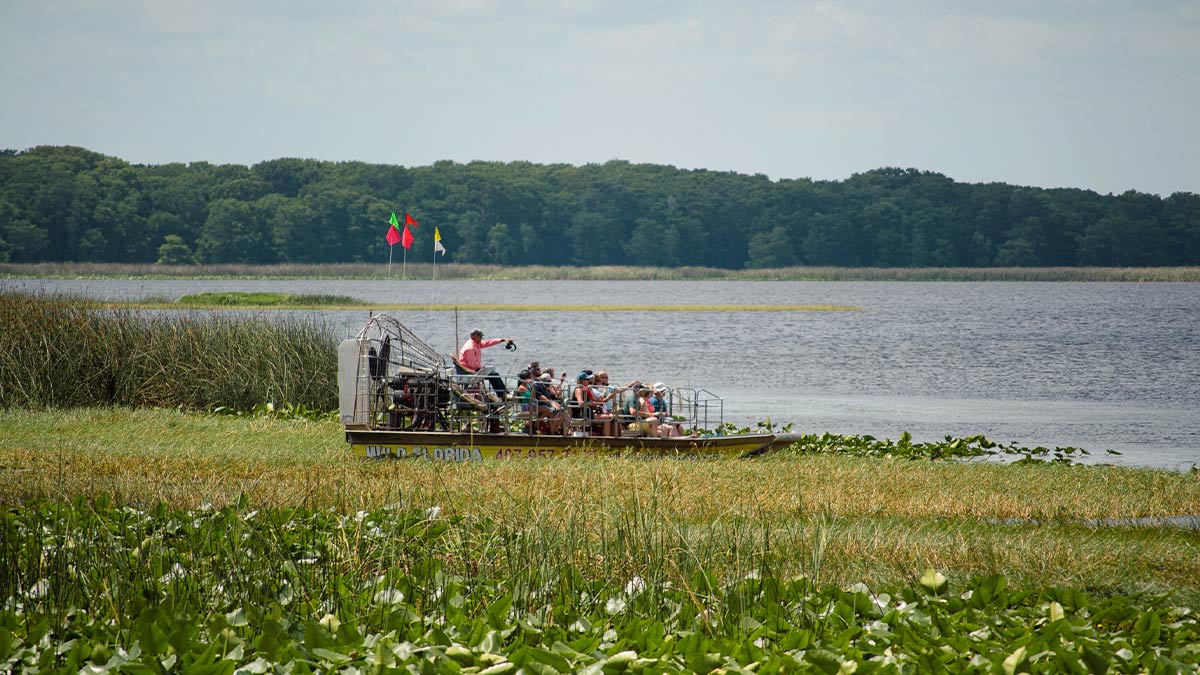 a picture of a people riding an airboat in the lake