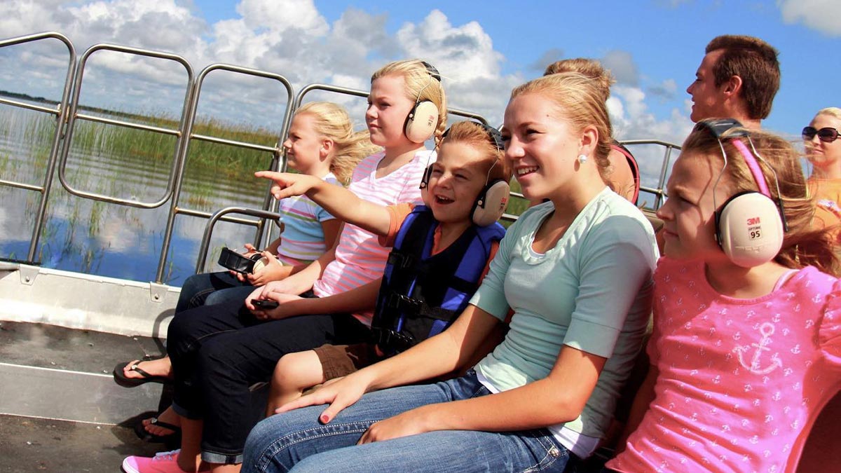 adults and children aboard Wild Florida Airboat Ride through Florida Everglades on sunny day in Orlando, Florida, USA