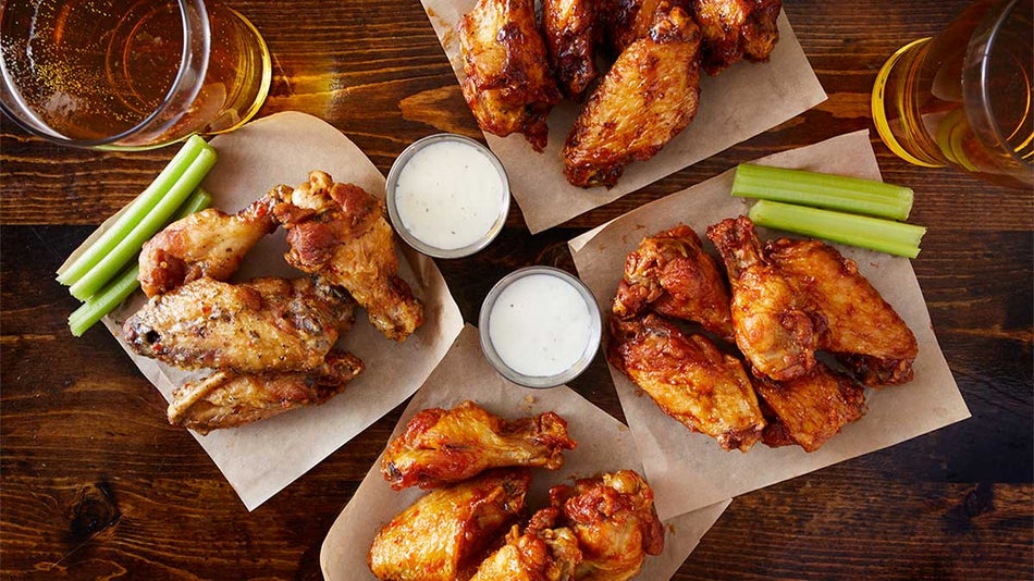 close up of chicken wings and celery sticks on side with dip and drinks on wooden table at Blue Moose Burgers and Wings in Gatlinburg, Tennessee, USA