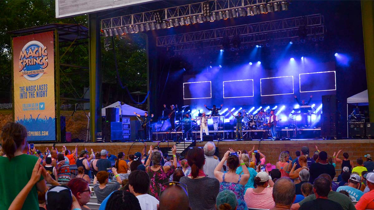 crowd watching performers on stage lit with blue lights at Magic Springs Theme Park in Hot Springs, Arkansas, USA