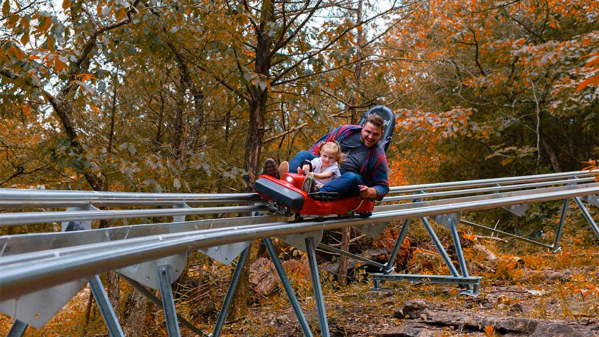 A lovely photo of a father and daughter riding in a mountain coaster which is one of the best branson attractions for kids