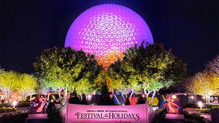 a lovely picture of the park with a large circular ball in the center and small trees on either side.