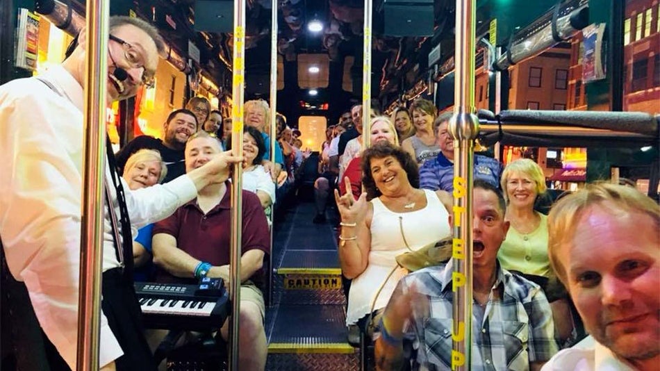 a group shot of a men and women riding a bus happily 