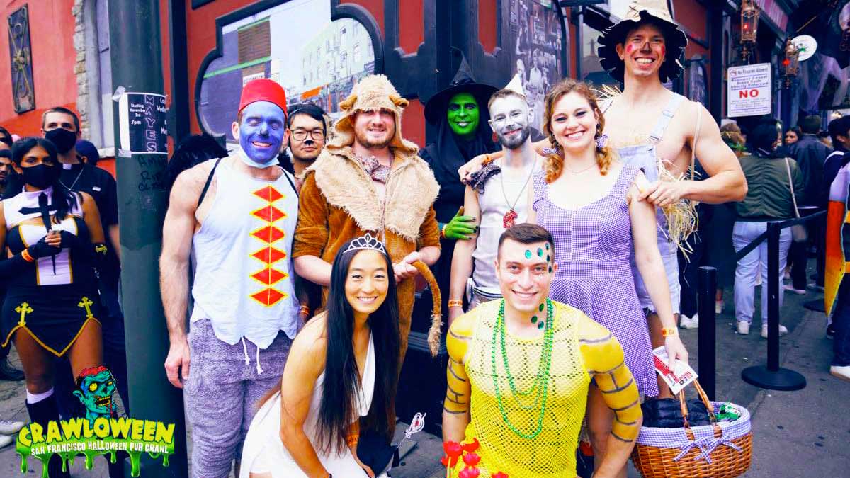 a group photo of people wearing different Halloween costumes.