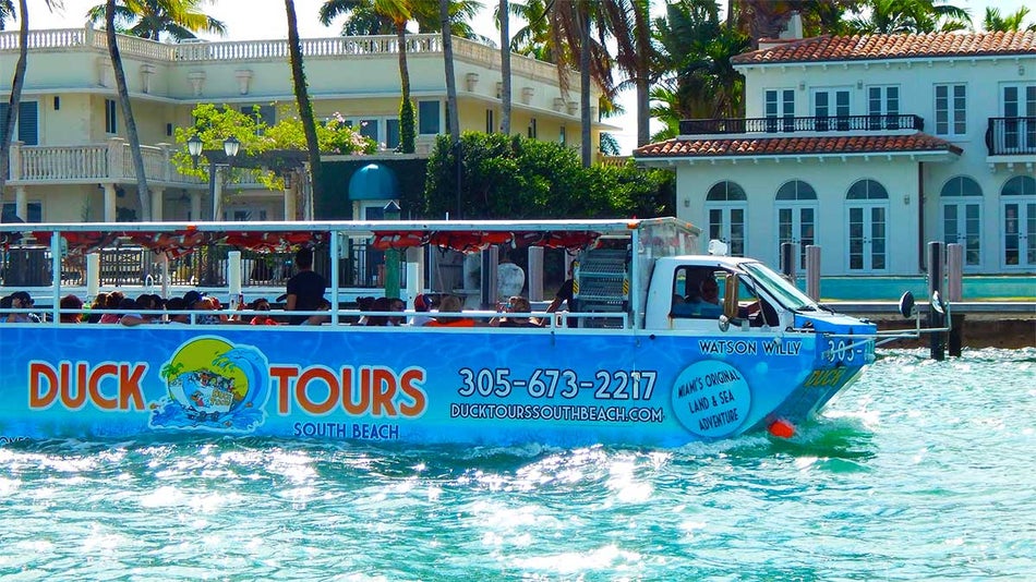 tourists on Duck Tour South Beach boat on water with houses in background at Miami Beach, Florida, USA