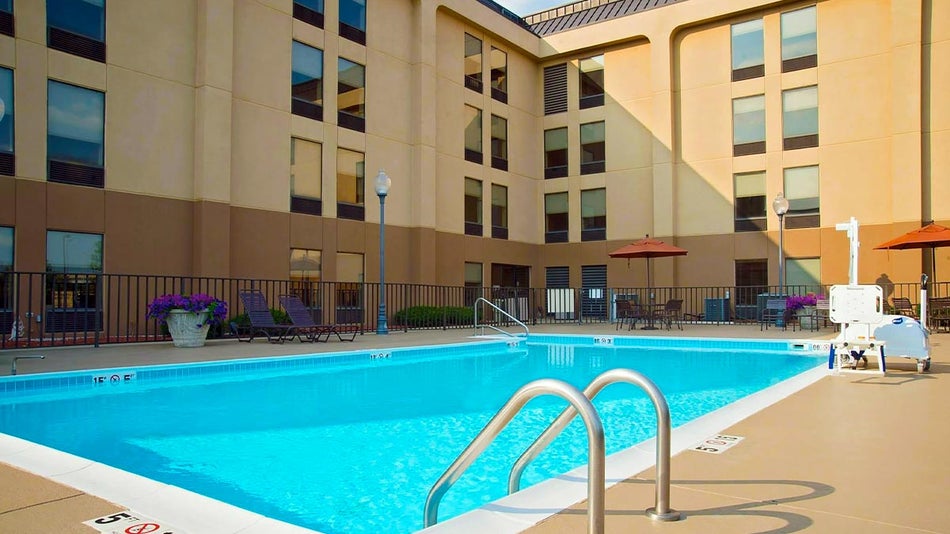 a picture of the Hampton Inn pool taken at an angle where both the hotel building and the pool are visible
