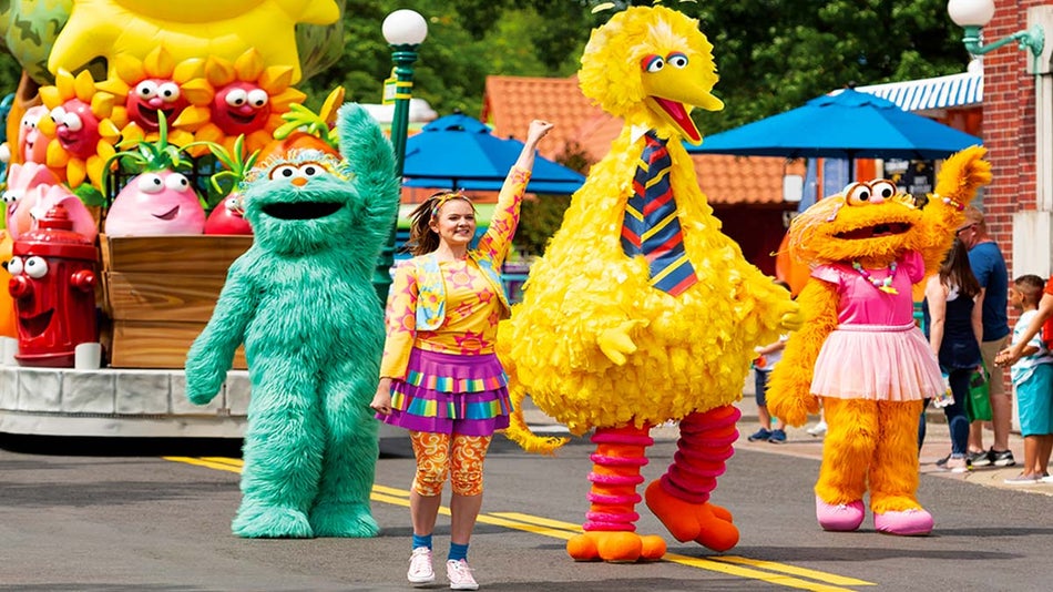 a photograph of a girl and a mascot dressed in costume in the middle of the road 