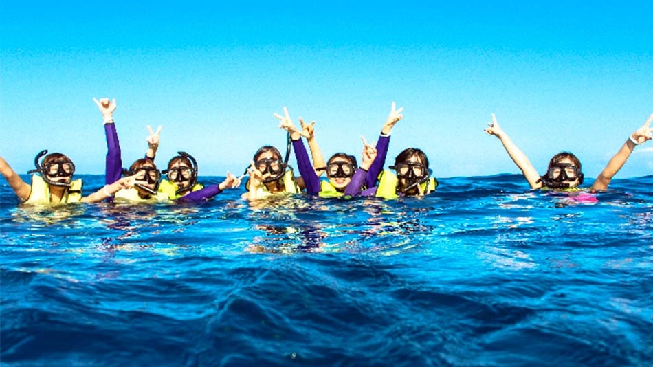 kids with snorkeling gear in water posing for photo on sunny day