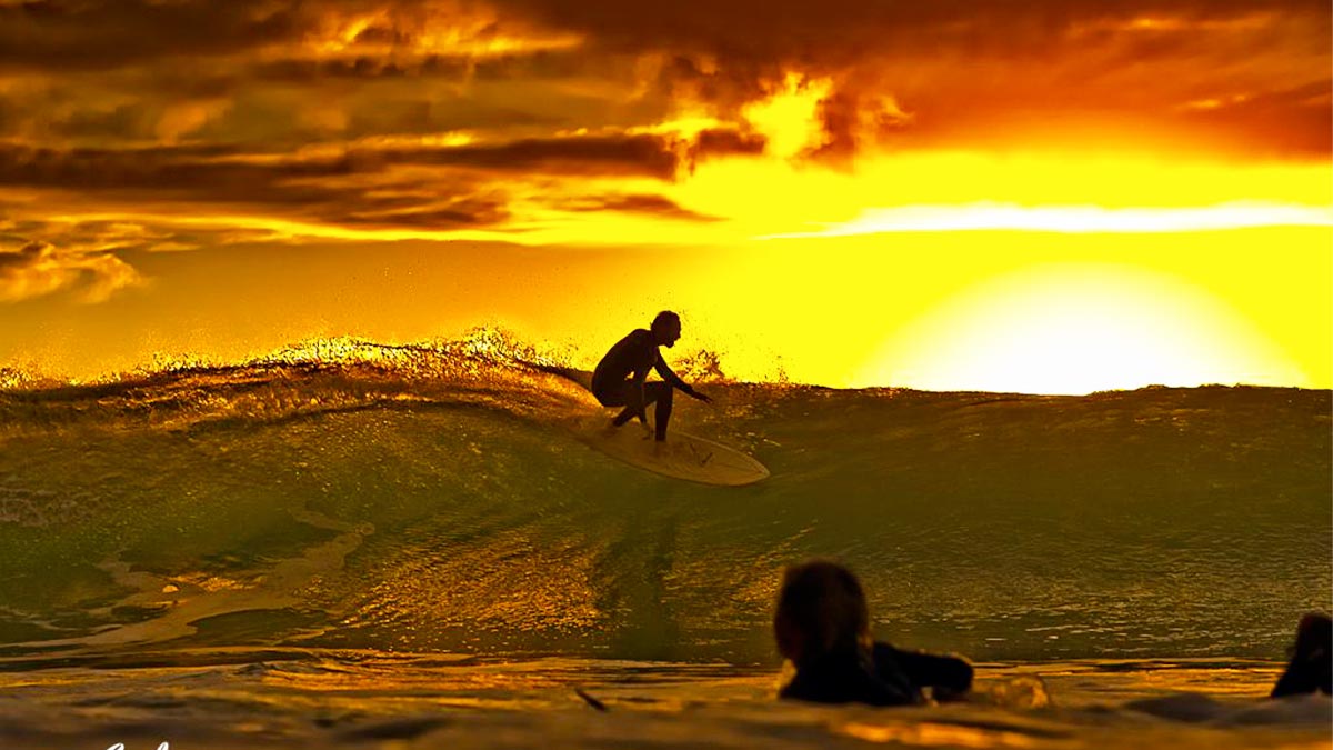 man surfing on wave during sunset at Blacks Beach La Jolla in San Diego, California, USA