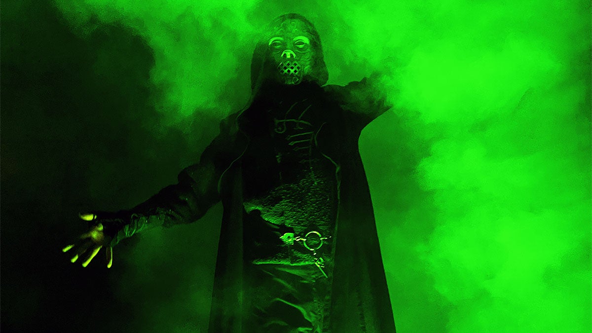 A man wearing a Halloween customer with a smoking green light effects.
