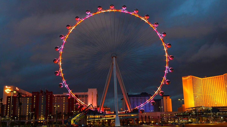 A photo of a big ferris wheel with buildings at the back