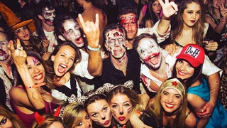 A group shot of both men and women having fun at the Halloween party. 