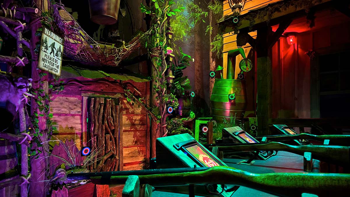room lit with colorful lights filled with wooden structures and plants at Shooting Gallery Beyond the Lens in Pigeon Forge, Tennessee, USA