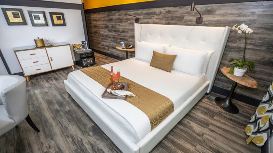 guest room with tray with wine on white bed, sidetables, and grey flooring, and walls at Catalina Hotel in Miami, Florida, USA