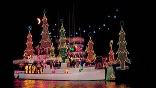 white ship covered in christmas lights and decorations in the water at night