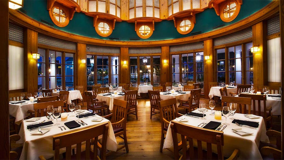 interior of Yachtsman Steakhouse with set dining tables and chairs at Epcot in Orlando, Florida, USA