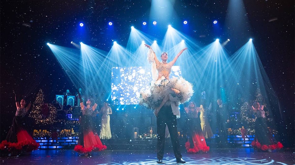 A woman being held in the air dancing with backup dancers at the Carolina Opry Christmas Special in Myrtle Beach, South Carolina, USA.