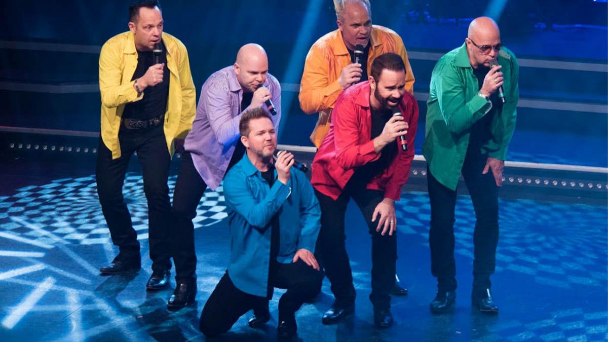 Performers holding microphones on stage singing for SIX Beach Boys in Branson, Missouri, USA