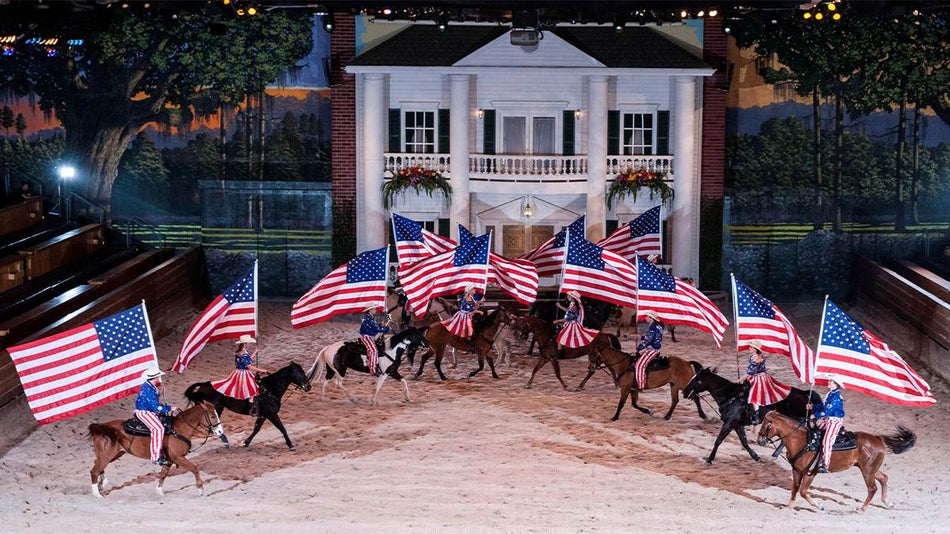 Close up of performers on horses holding American Flags at Dolly Parton's Stampede in Branson, Missouri, USA