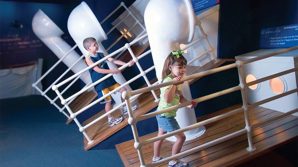 Kids standing on various stages of the deck tilting at the Titanic Museum in Branson, Missouri, USA