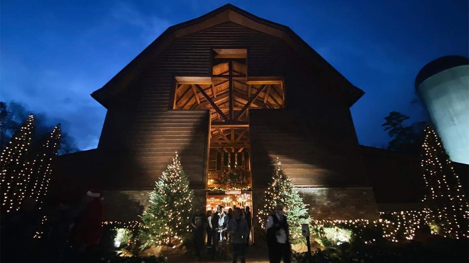 Close up photo of the barn at Billy Graham Library at night with Christmas trees outside of it in Charlotte, North Carolina, USA