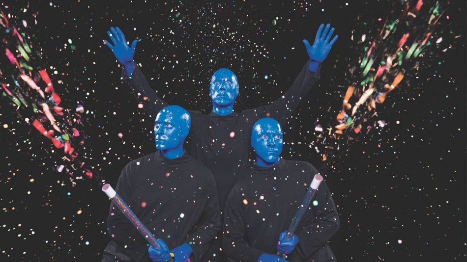 three performers from the Blue Man Group shooting off confetti guns in Chicago, Illinois, USA