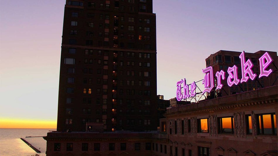 Close up view of the pink neon sign that says "The Drake" in black letter font on top of The Drake Hotel in Chicago, Illinois, USA