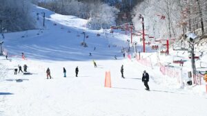 Wide shot of people skiing and snow boarding down the slopes at Ober Gatlinburg in Gatlinburg, Tennessee, USA